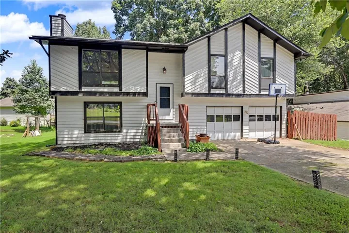 Split-level exterior with white siding and dark trim accents