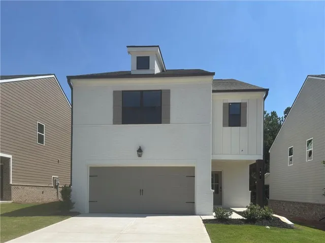 Contemporary exterior with white brick and vertical siding accents, two-car garage, dormer window, and covered entry