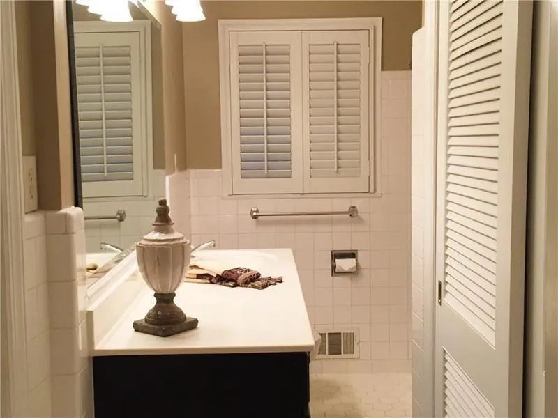 Bathroom with vanity, tile walls, and wainscoting