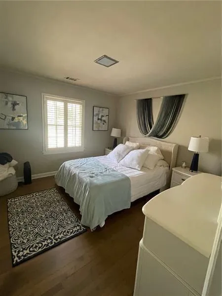 Bedroom featuring ornamental molding and dark wood-style floors