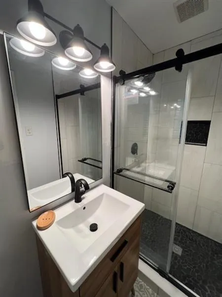 Full bath with vanity and a stall shower