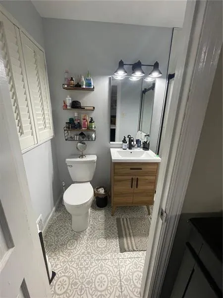 Half bath with vanity and light tile patterned flooring