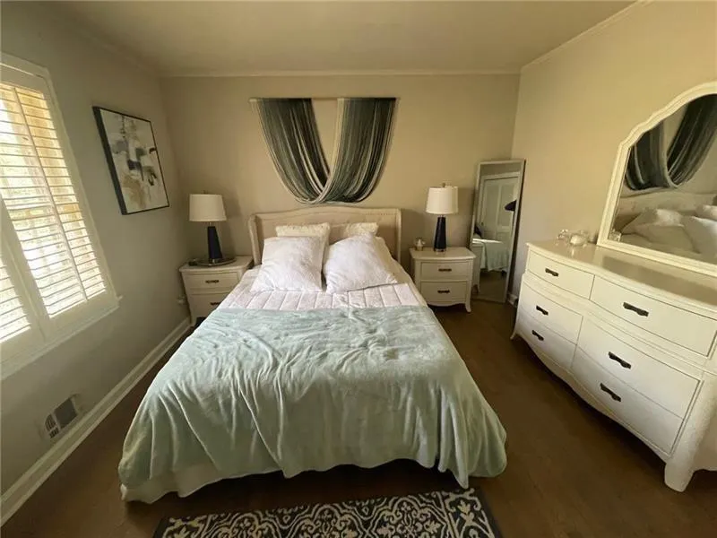 Bedroom with ornamental molding and dark wood-style floors