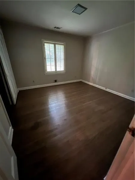 Empty room with dark wood-style floors and baseboards