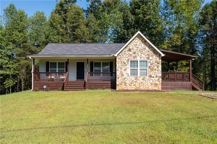 Stone-clad exterior with a covered front porch and an attached covered deck
