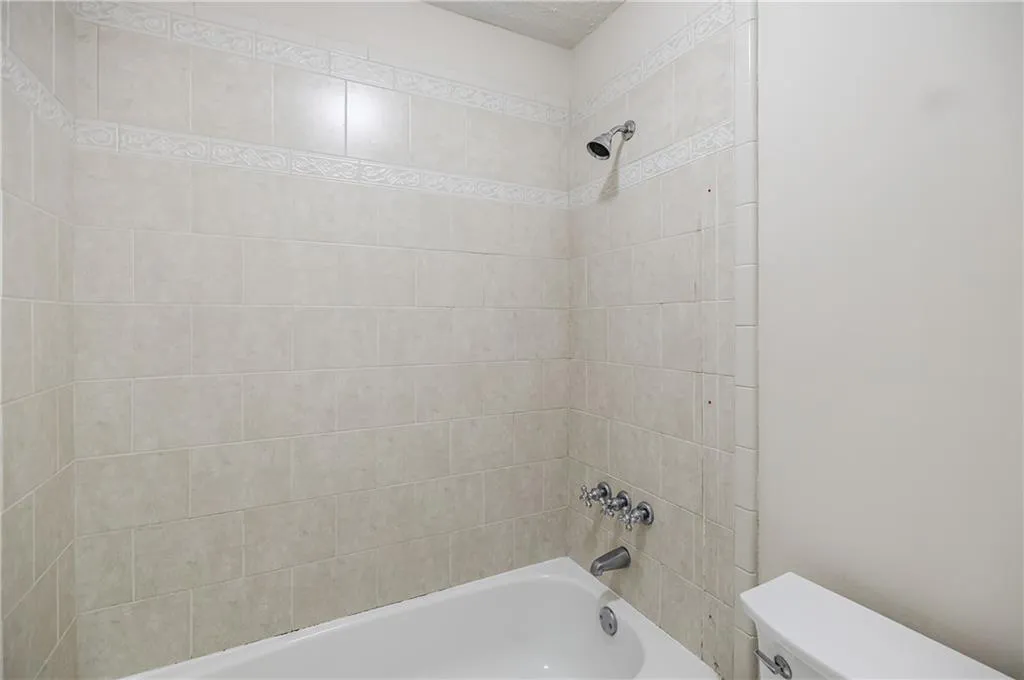 Bathroom featuring shower / bath combination and toilet