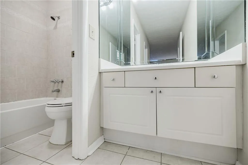 Bathroom featuring light tile patterned floors, vanity, and tub / shower combination
