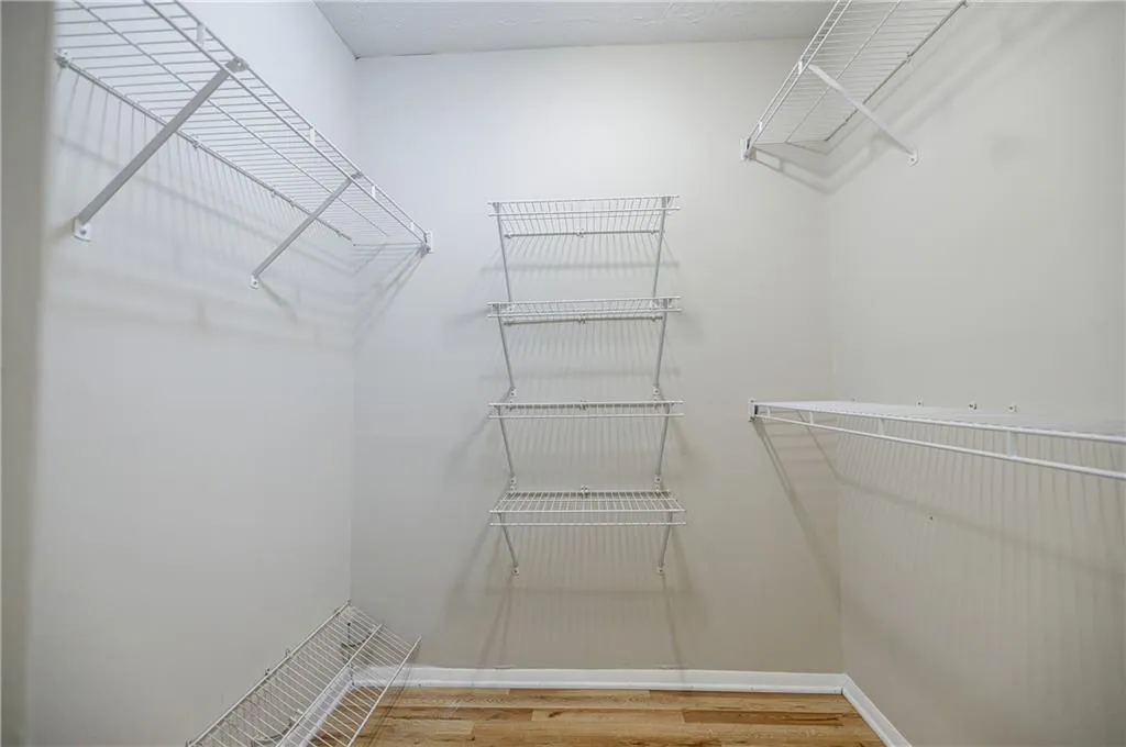 Spacious walk in closet featuring light wood finished floors
