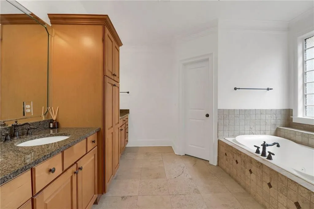 Bathroom featuring vanity, a garden tub, and crown molding