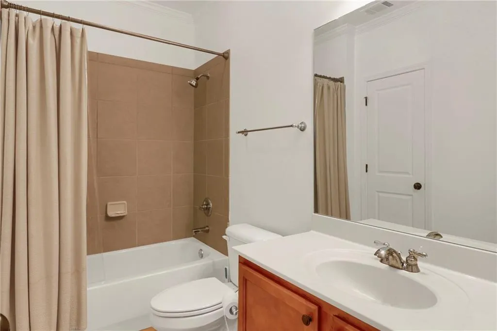 Bathroom featuring ornamental molding, vanity, and shower / bathtub combination with curtain