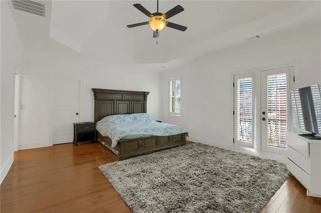 Bedroom featuring access to exterior, wood finished floors, and ceiling fan