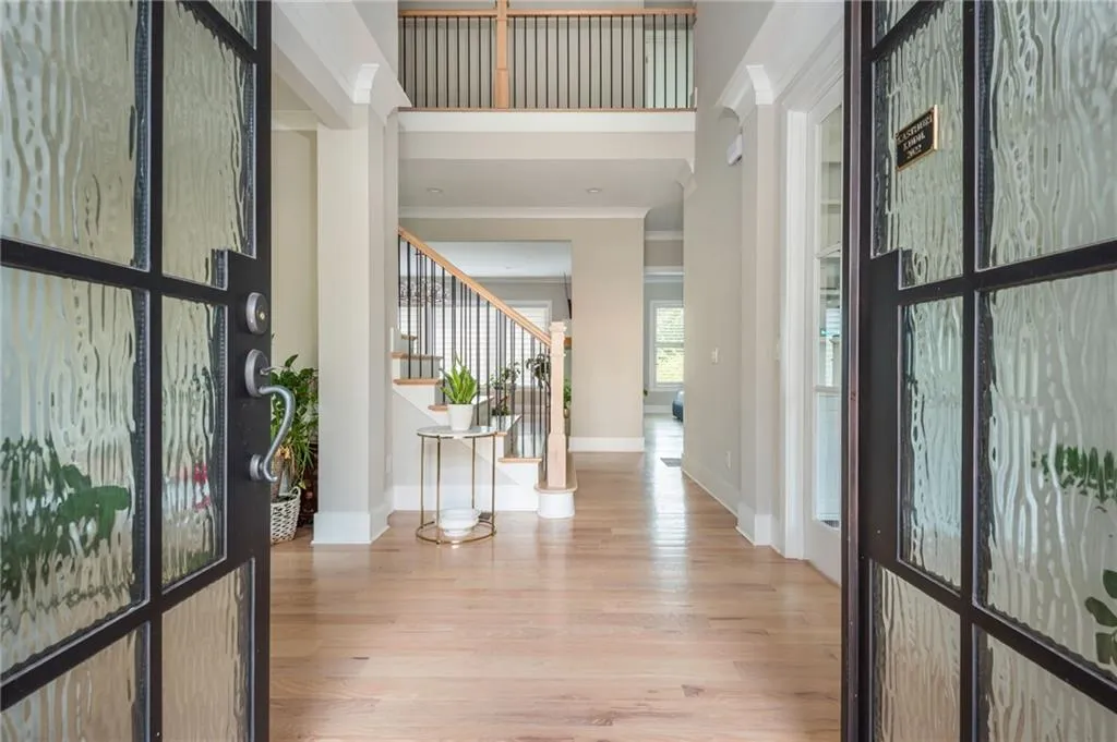 Entryway with stairs, crown molding, baseboards, and wood finished floors.