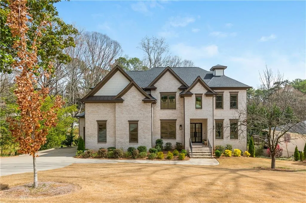 View of front of house with brick siding, concrete driveway, and roof with shingles