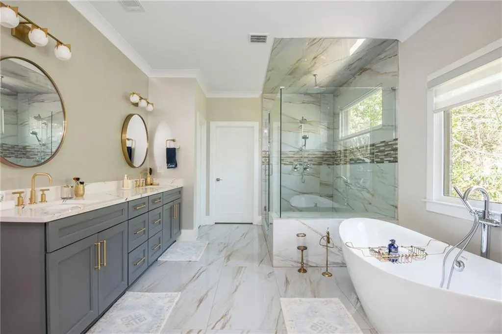 Full bath with a marble finish shower, a freestanding bath, and artistic lights and fixtures
