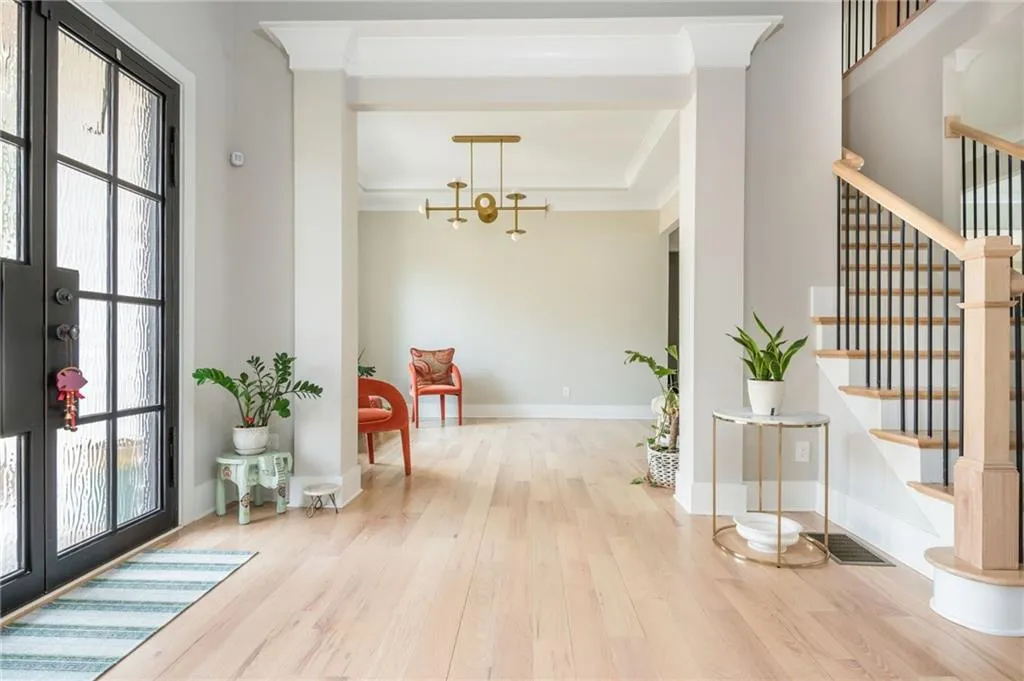 Foyer with stairway, wood finished floors, and ornamental molding