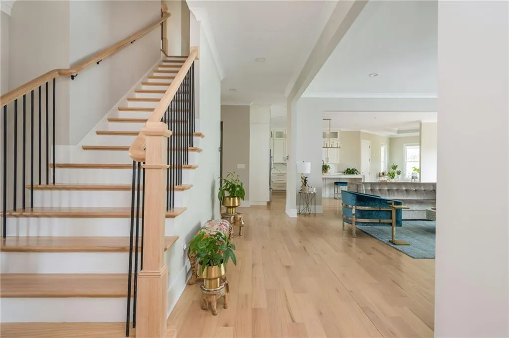 Staircase with ornamental molding and wood finished floors