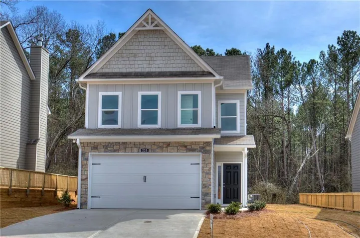Contemporary two-story residence featuring light gray siding and natural stone accents