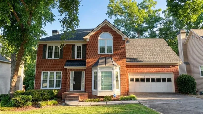 Brick exterior with a prominent bay window and an arched window accent