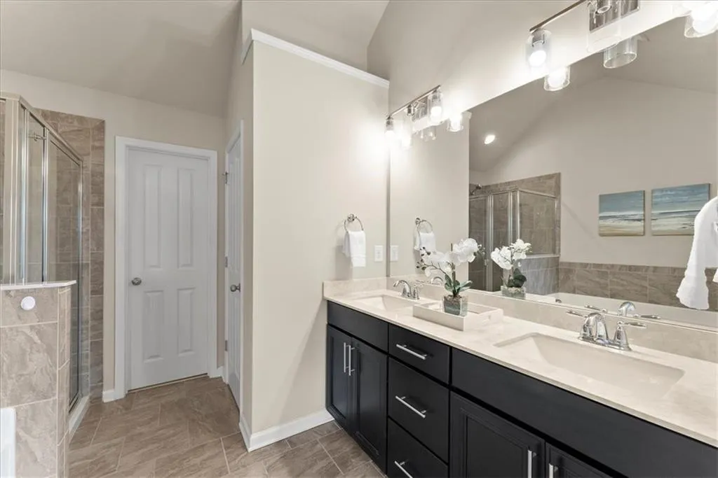 Primary Bathroom featuring lofted ceiling, independent shower and bath, and vanity