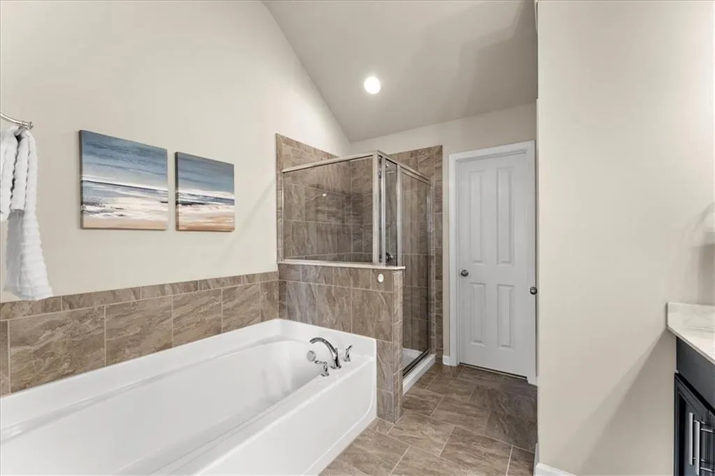 Bathroom with vaulted ceiling, independent shower and bath, and vanity
