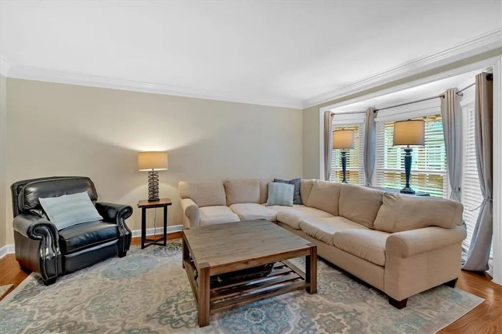 Living area featuring ornamental molding, wood finished floors, and baseboards