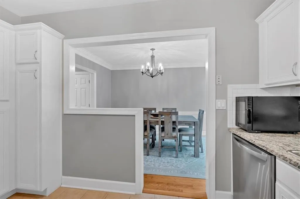Dining area featuring a chandelier, baseboards, crown molding, and light wood-style flooring