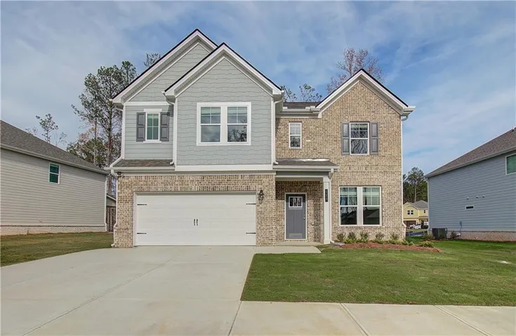 Two-story residence featuring brick and siding exterior, an attached garage, a covered entry, and a concrete driveway
