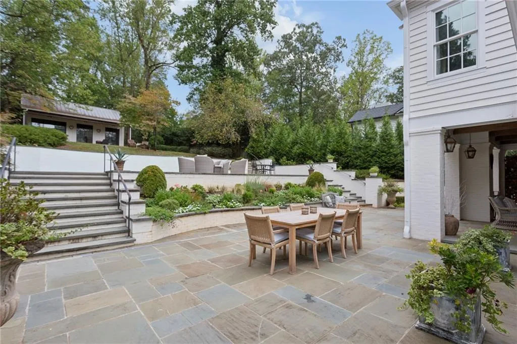 Multi-level hardscaping with stone steps, a flagstone patio, and a dedicated dining area
