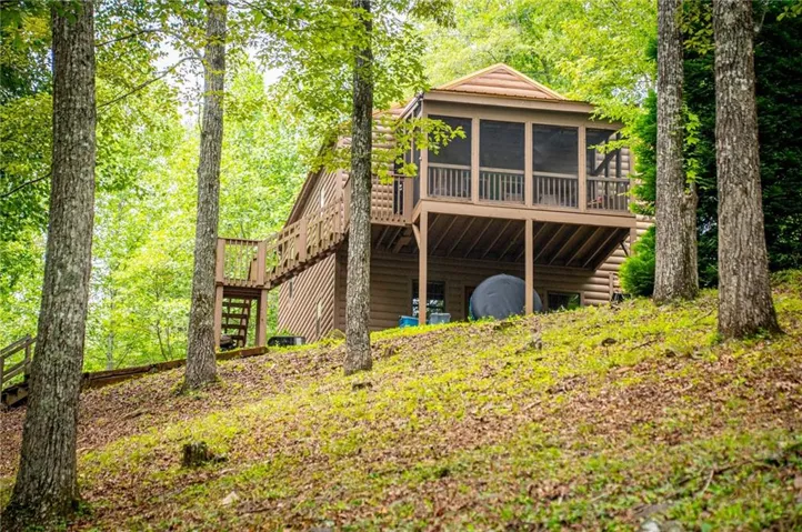 Wood-sided cabin featuring a screened porch and expansive outdoor decking
