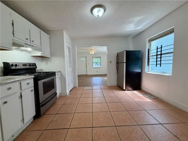 Kitchen featuring tile flooring, white cabinetry, and a built-in range