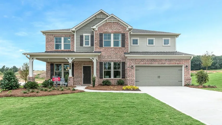Two-story brick exterior with a covered front porch, a two-car garage, and a concrete driveway