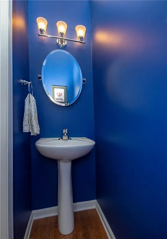 Bathroom with baseboards and dark wood-type flooring