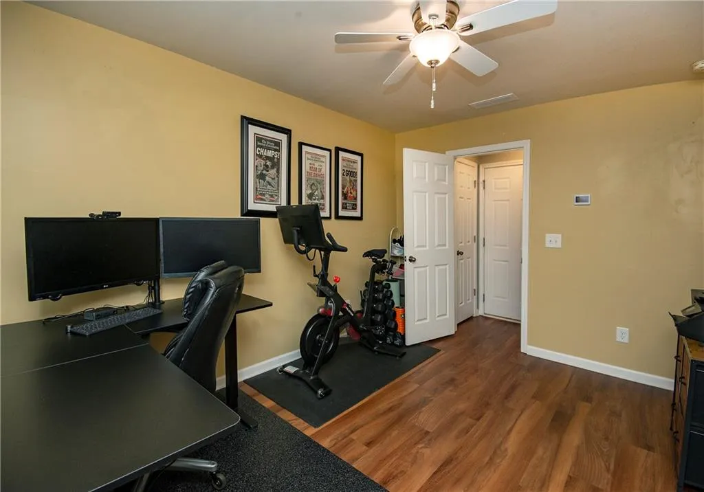 Office area featuring dark wood finished floors and a ceiling fan