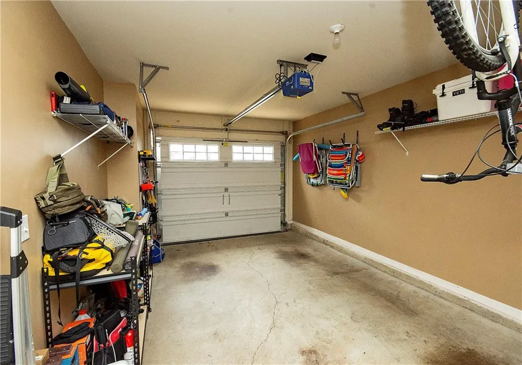 Garage featuring a garage door opener and baseboards