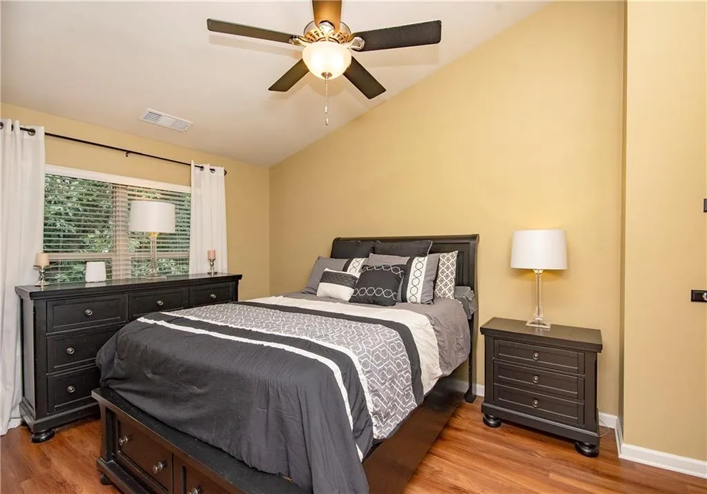 Bedroom featuring lofted ceiling, wood finished floors, and ceiling fan