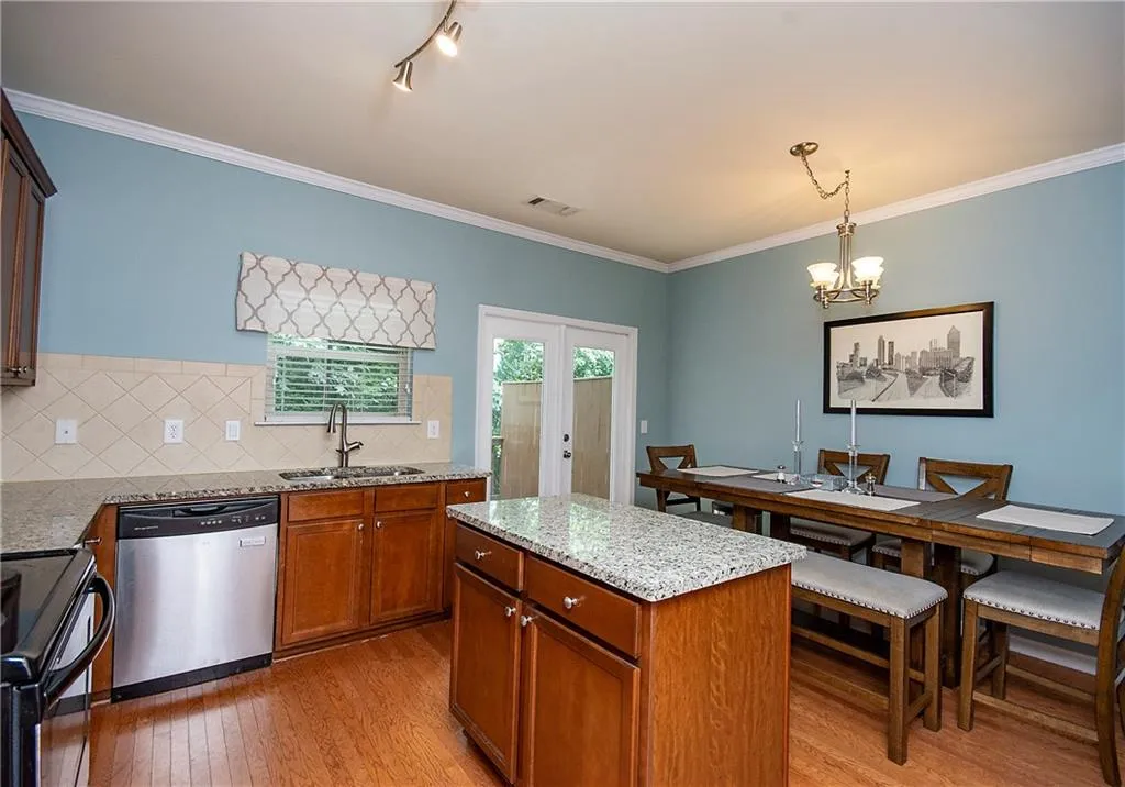 Kitchen with crown molding, light stone counters, black / electric stove, dishwasher, and tasteful backsplash