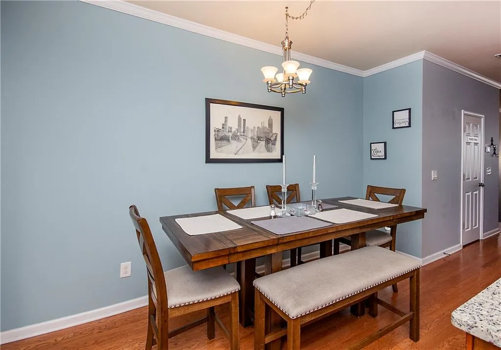 Dining area featuring ornamental molding, wood finished floors, and a chandelier