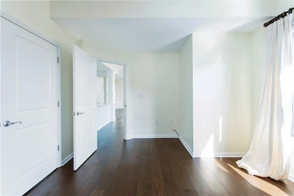 Hallway with healthy amount of natural light and dark wood-style floors