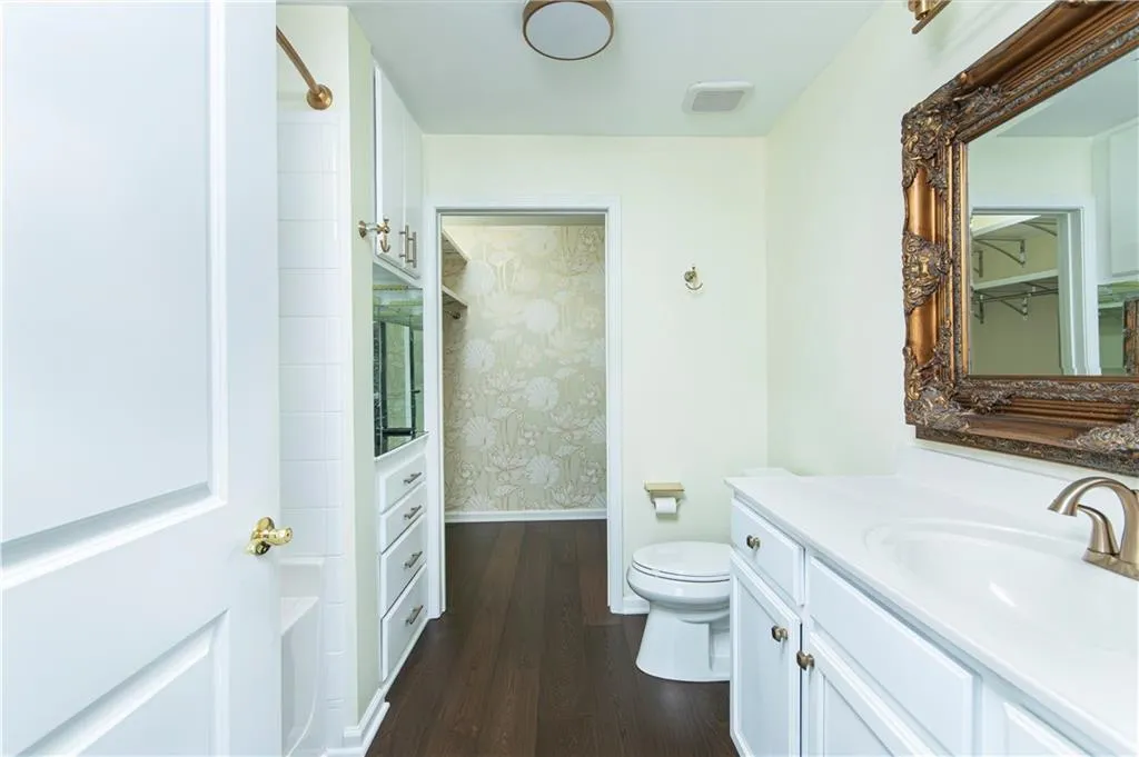 Bathroom with vanity, dark wood-style flooring, and shower / bathtub combination
