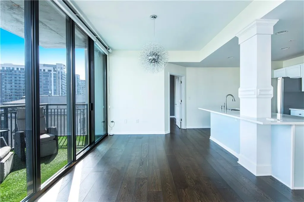 Unfurnished dining area with dark wood-type flooring, a chandelier, and expansive windows