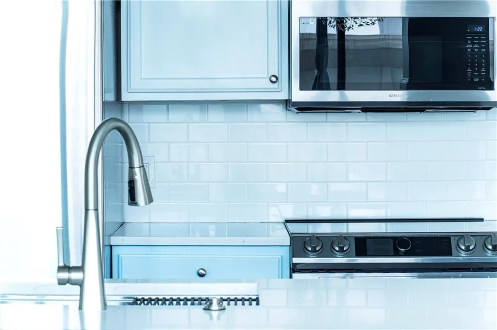 Kitchen view of stainless steel appliances and light stone counters