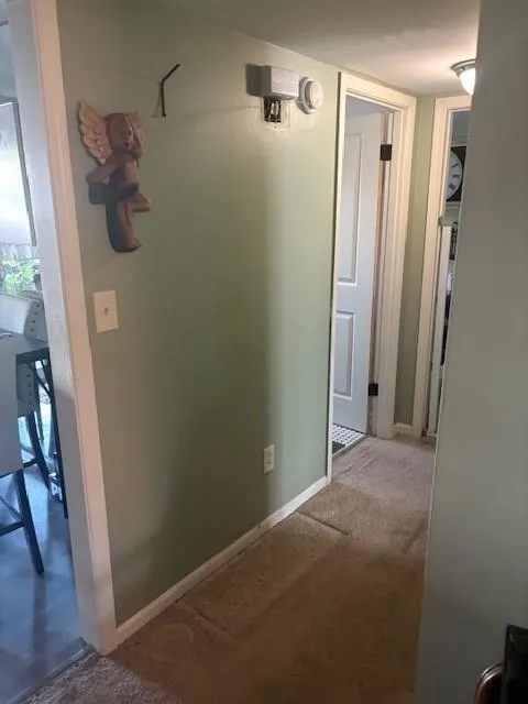 Hall featuring carpet flooring and baseboards