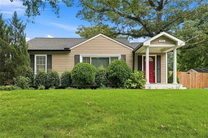 Siding exterior with dark shutters, covered front entry with white columns, and a red front door