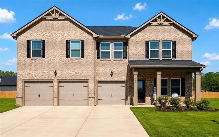 Brick exterior with a covered entry, multiple windows featuring black shutters, and a three-car garage