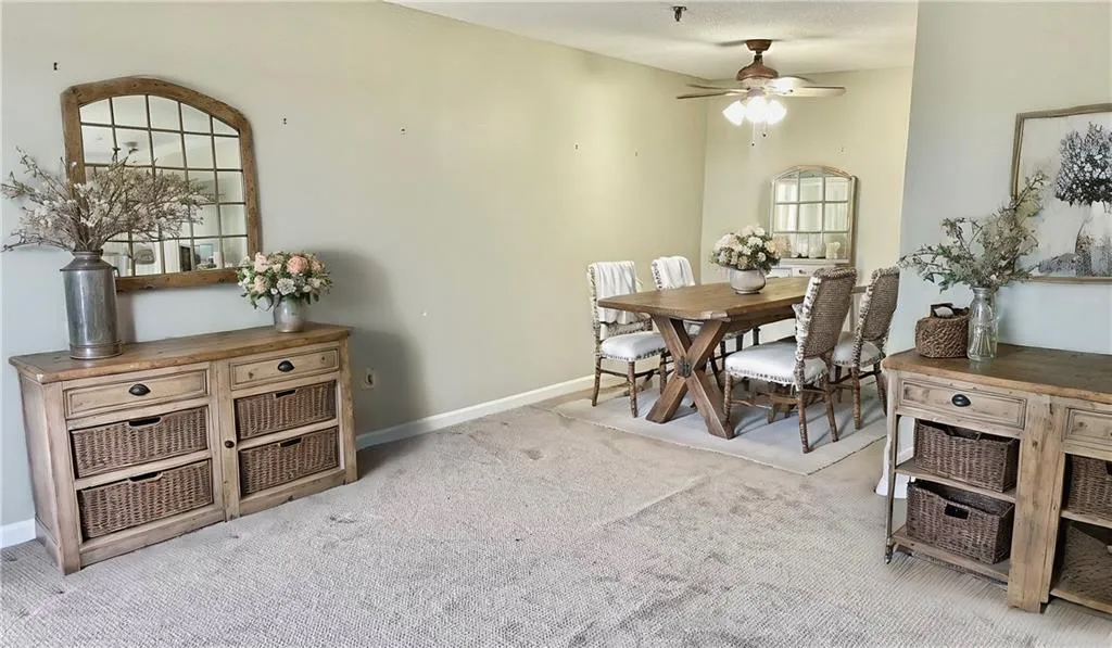 Dining room with light carpet and ceiling fan
