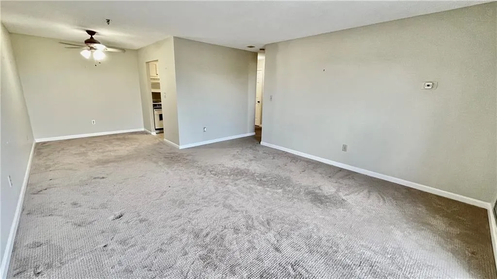 Carpeted empty room featuring ceiling fan