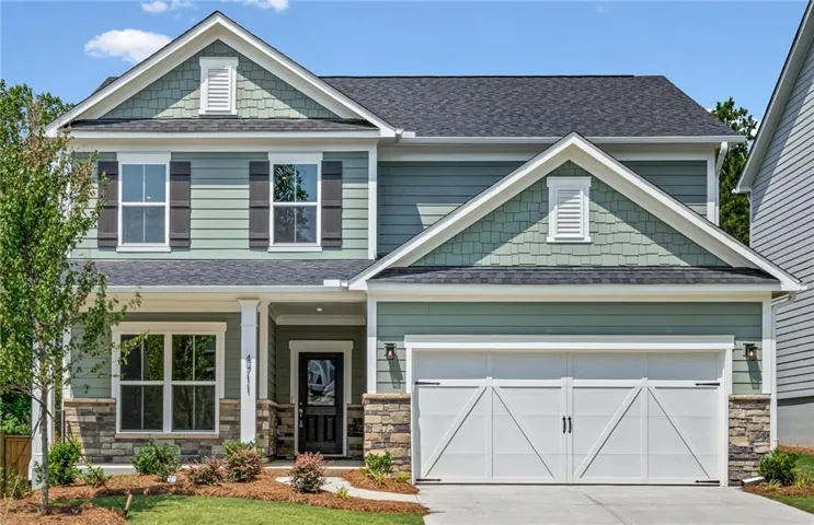 Two-story residence featuring a combination of horizontal siding, shake siding, and stone veneer accents