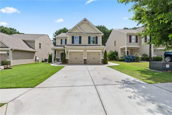Craftsman house with a front yard, a garage, and concrete driveway