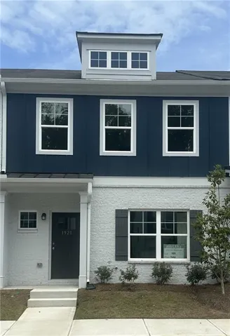 Brick and siding exterior featuring a dormer window, covered entry, and decorative window shutters