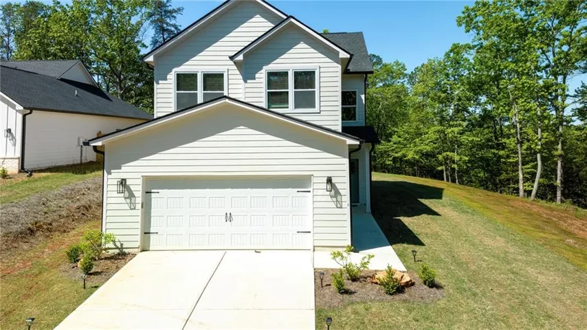 Two-story residence featuring light-colored siding and a dark-shingled roof
